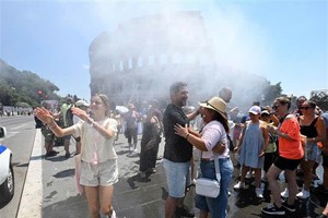 2026年6月26日，在意大利罗马，当地民众在炎热天气中靠近喷雾装置来降温。越通社