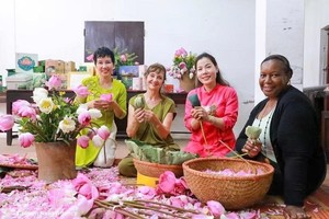 游客体验广安荷花茶窨制工艺。图自越通社