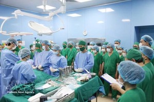 医护人员和专家在手术前向这位19岁器官捐献者及其家人低头默哀，表达由衷的感谢。图自越通社