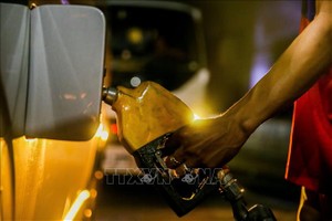 在菲律宾奎松一家加油站工作人员正在给车辆加油。示意图：新华社/越通社