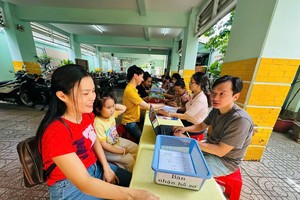 家长在旧邑坊金童小学办理2026-2027学年度一年级入学申报手续。示意图。