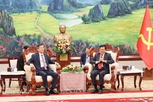 老挝人民革命党中央总书记、国家主席通伦·西苏里（右）会见前来礼节性拜会的党中央政治局委员、胡志明国家政治学院院长段明训副教授。图自越通社
