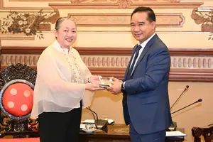 胡志明市人委会主席阮文得向菲律宾驻胡志明市总领事克罗宾·戴佩拉·拉凯赠送纪念品。图：越勇