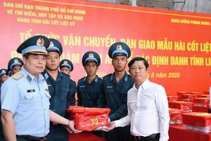 胡志明市人民议会主席武文明与防空—空军军种司令武鸿山中将将烈士遗骸生物样本移上专用车辆，运往越南科学与技术翰林院DNA鉴定中心。图：光福
