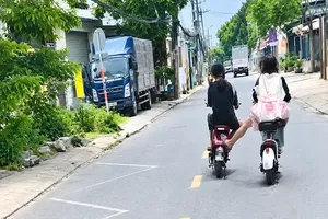 骑2辆电动自行车在路上蛇行穿梭，并在卡车前方切道的一伙少年。图自HT