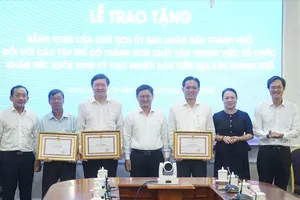 胡志明市人委会副主席阮孟强向在组织居民定期健康检查中取得优异成绩的3个集体颁发奖状。