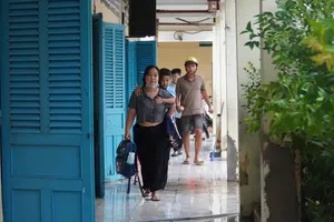 大雨后校园严重积水，家长背着孩子进教室。