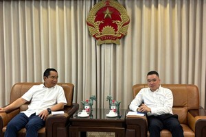 胡志明市人委会主席阮文得与越南驻上海总领事陈辉雄交流。图: 陈雄、阮国
