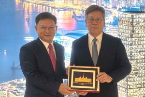 胡志明市人委会副主席阮孟强向香港特别行政区政府商务及经济发展局局长丘应桦赠送纪念品。图: 胡志明市外务厅
