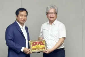 胡志明市人委会主席阮文得向临港新片区管委会领导赠送纪念品。图:陈雄、阮国