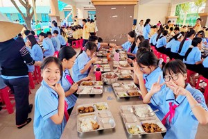 平新坊胡文龙初中学校学生在校食用午餐。