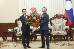 阮明心大使转交越南党中央政治局委员、政府总理黎明兴致沙伦赛·贡玛西同志所致的贺信与花篮。图自越通社