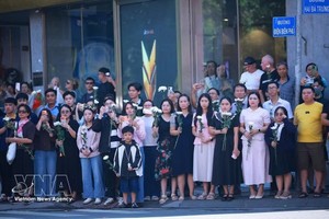 胡志明市广大市民手持白花送别烈士遗骸归葬胡志明市烈士陵园。图：越通社