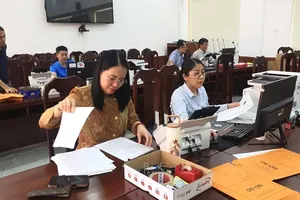 胡志明市各党机关党委领导与干部正在进行档案资料数字化工作。