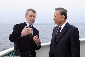 丹麦国王弗雷德里克十世在乘船前往利奈特霍尔姆岛途中，向越南党中央总书记、国家主席苏林介绍利奈特霍尔姆人造岛项目。图自越通社