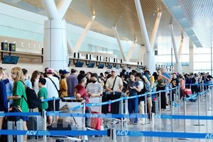 国内外旅客在新山一机场T3航站楼排队办理安检手续。资料图：越通社发
