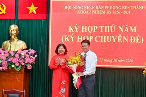胡志明市人民议会副主席阮长日凤赠送鲜花祝贺滨城坊人委会主席。