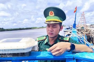 银豪边防检查站站长潘明王少校对渔船VMS设备进行检查。图自越通社