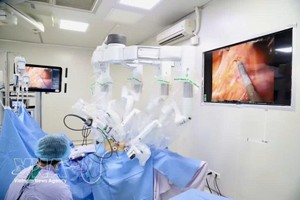 在机器人辅助腹腔镜手术的帮助下，医生们成功完成了复杂的手术。图自越通社