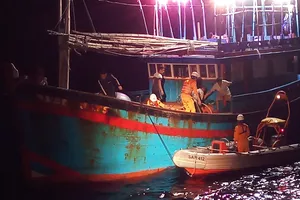 Các nhân viên cứu nạn đưa ngư dân Huỳnh Văn Cương sang tàu cứu nạn bằng xuồng cao su 