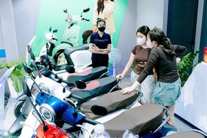 顾客在铃春坊苏玉云街一家代理商听取电动摩托车谘询。