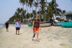 外国游客在避风角渔村海边漫步。