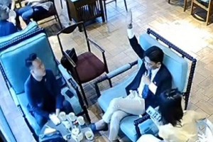 穿西装的男子举手示意并喊着“够了，够了，够了”。