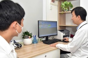 嘉定人民医院的医生正为患者诊病并在电子病历创建信息。