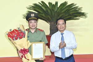 胡志明市人委会主席阮文得向梅皇中将颁发政府总理的表扬信。