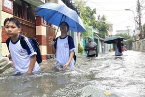 10月16日，庆和省北芽庄坊阮勝初中学生在水中跋涉回家。图：阮黄