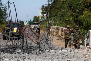 12月20日，在柬埔寨奥多棉吉省，士兵正在检查一座在泰国空袭中受损的桥梁。（图片：法新社）