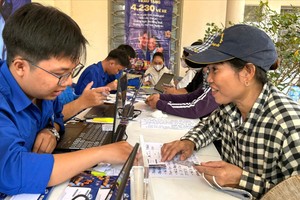 籍贯嘉莱省、从事废品收购的阮氏丽高兴地领到春节返乡车票。