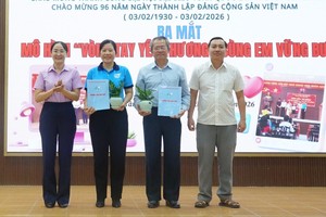 新泰协坊党委常务副书记阮晋力与坊人委会副主席阮氏英诗颁发模式启动决定并赠送盆栽祝贺。