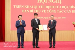 党中央政治局委员、中央书记处书记、中央组织部部长黎明兴向陈辉俊同志颁发决定。图：越通社