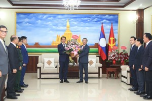 越南驻老挝大使阮明心转交越南共产党中央总书记苏林致老挝人民革命党建党71周年的花篮。图：越通社