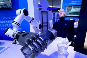 3月27日在2026中关村论坛年会展览上拍摄的“北脑一号”智能脑机系统启动机械臂往杯里倒水。图：新华社记者 魏梦佳