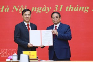 范明政总理向河内国家大学新任校长裴世维颁发任命《决定》。图：越通社