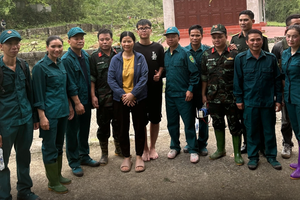 男学生和其母亲与救援队合影。