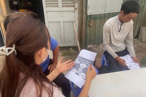 福胜坊医疗站发放传单，指导民众防控狂犬病。图：胡志明市疾控中心