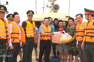 海防市人委会副主席陈文郡向遇险渔民赠送慰问品。图：越通社