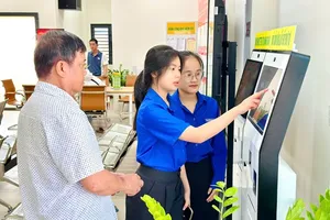 在胡志明市平新坊公共行政服务中心，志愿者队伍正现场引导民众办理行政审批手续。图：黎明