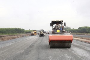 25C道路项目通往隆城机场1号门路段的路面施工机械正在作业。