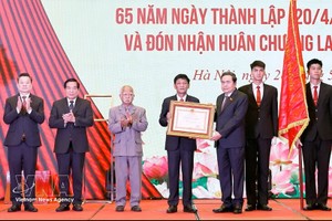 国会主席陈青敏代表党和国家领导人，向民族理事会颁授一等劳动勋章。图：越通社