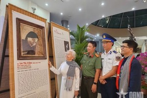 昆仑岛特区前政治犯黎秀锦观看年轻时期的肖像画。图:qdnd.vn