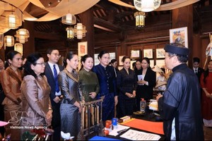 越南政府总理黎明兴夫人与老柬泰三国总理夫人听取越南书法艺术的介绍。图：越通社