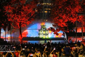 大批民众聚集在还剑湖畔，观看3D灯光秀。图：越通社