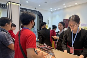 民众在胡志明市的一家保信孟海品牌金店进行黄金交易。图：阮黄