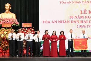 胡志明市人委会副主席陈文柒向市人民法院领导移交传统旗帜。图：越勇