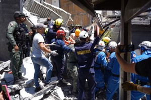救援人员于2026年8月10日在哥伦比亚马尼萨莱斯市一栋因地震倒塌的建筑物废墟中搜寻遇难者。图：新华社/越通社