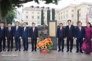 越南共产党中央政治局委员、中央书记处常务书记陈锦秀同越南共产党高级代表团在胡志明主席雕像和纪念碑前敬献鲜花，缅怀胡志明主席。图：越通社